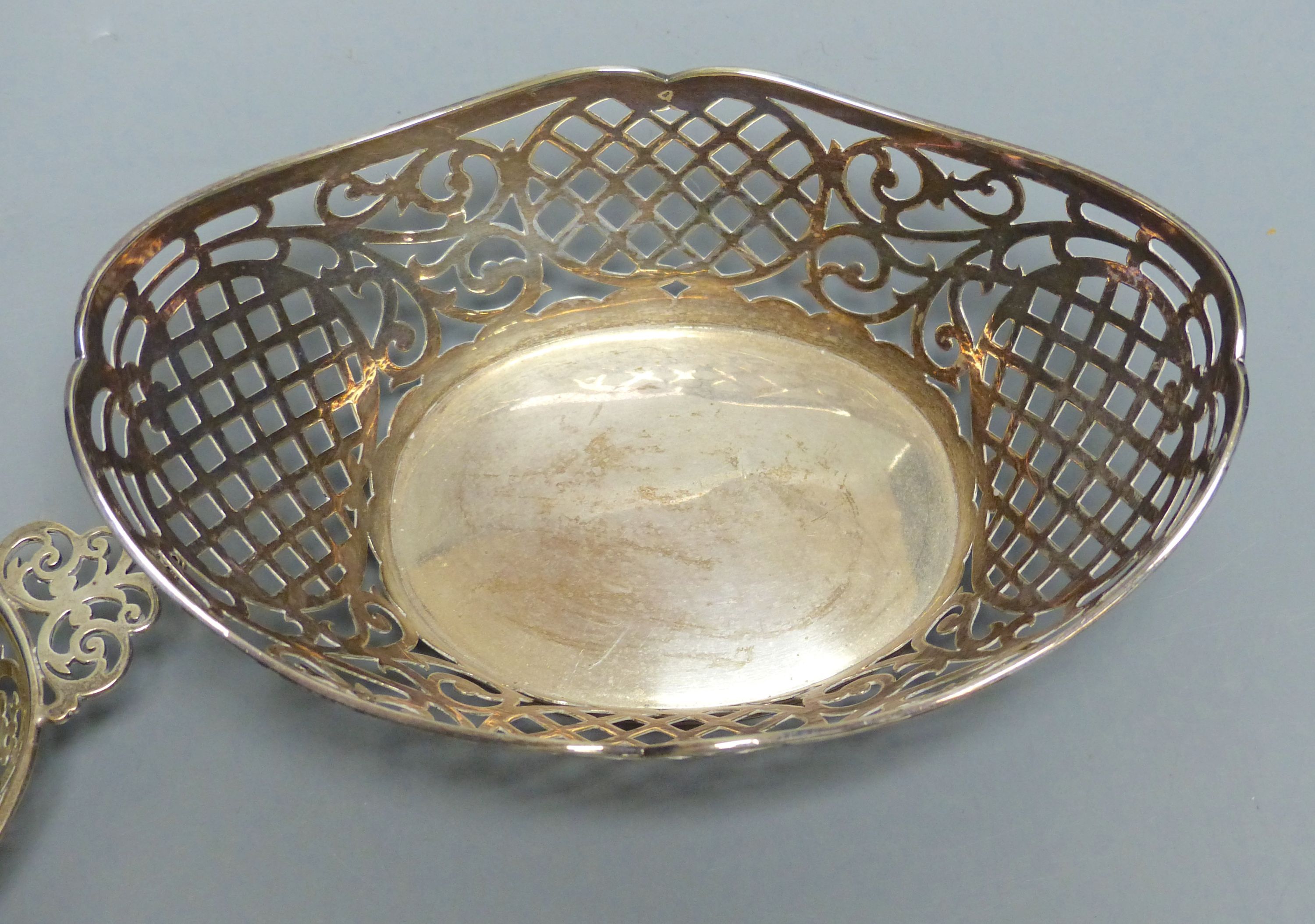 An Edwardian silver oval bon bon dish with pierced flower and scroll decoration and a Dutch white metal sweetmeat basket